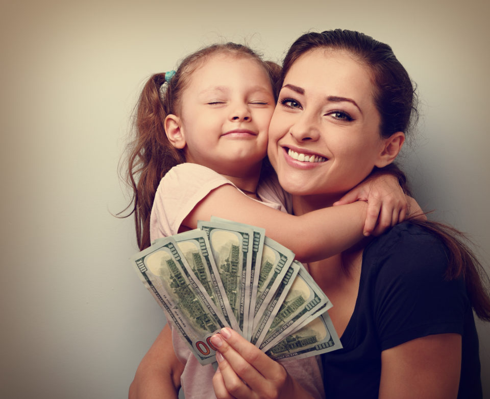 Woman and daughter smiling from having cash