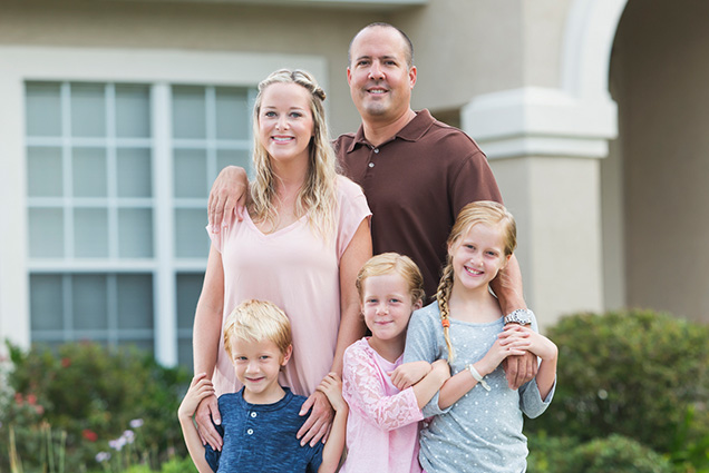 Happy family in front of home